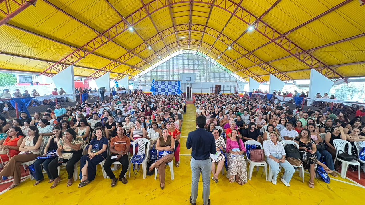 Natan Andrade diante de uma plateia lotada em ginásio, durante palestra aberta.